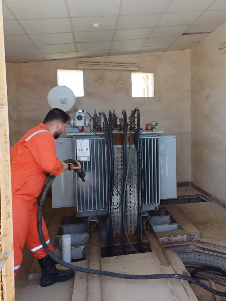 Technician servicing an electrical transformer